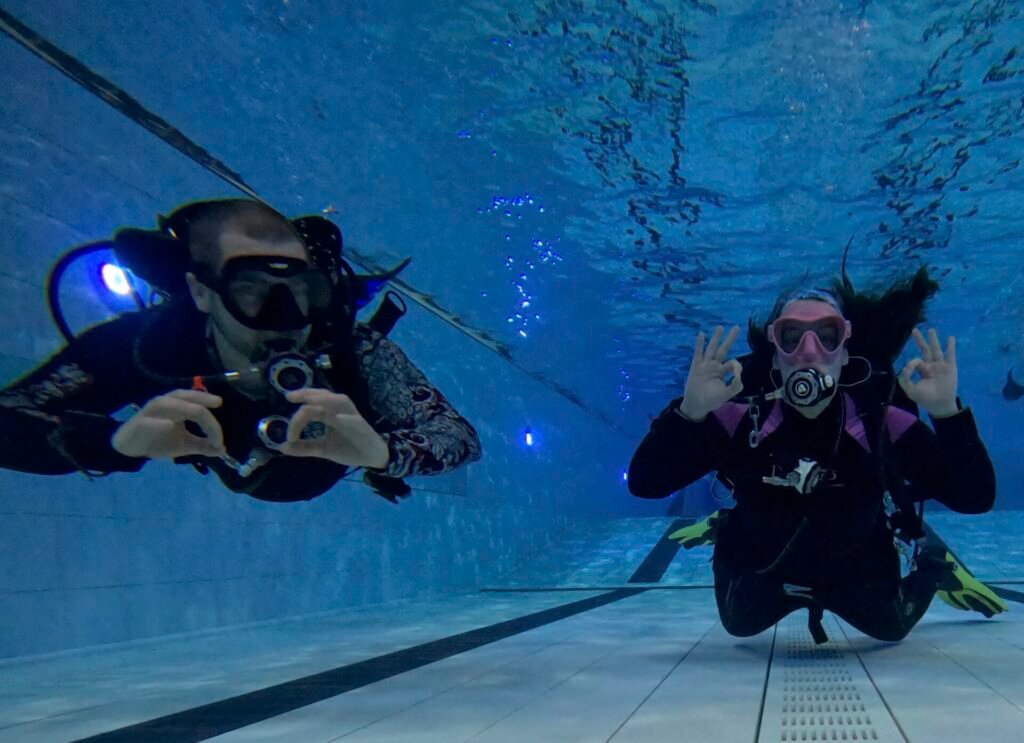Instructor and student in scuba gear in a swimming pool